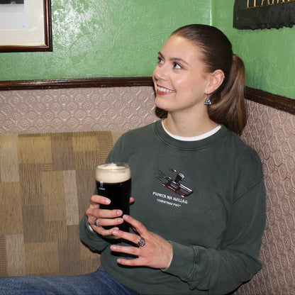 Bronagh in a pub wearing a green christmas jumper with a pint on a sled embroidered 