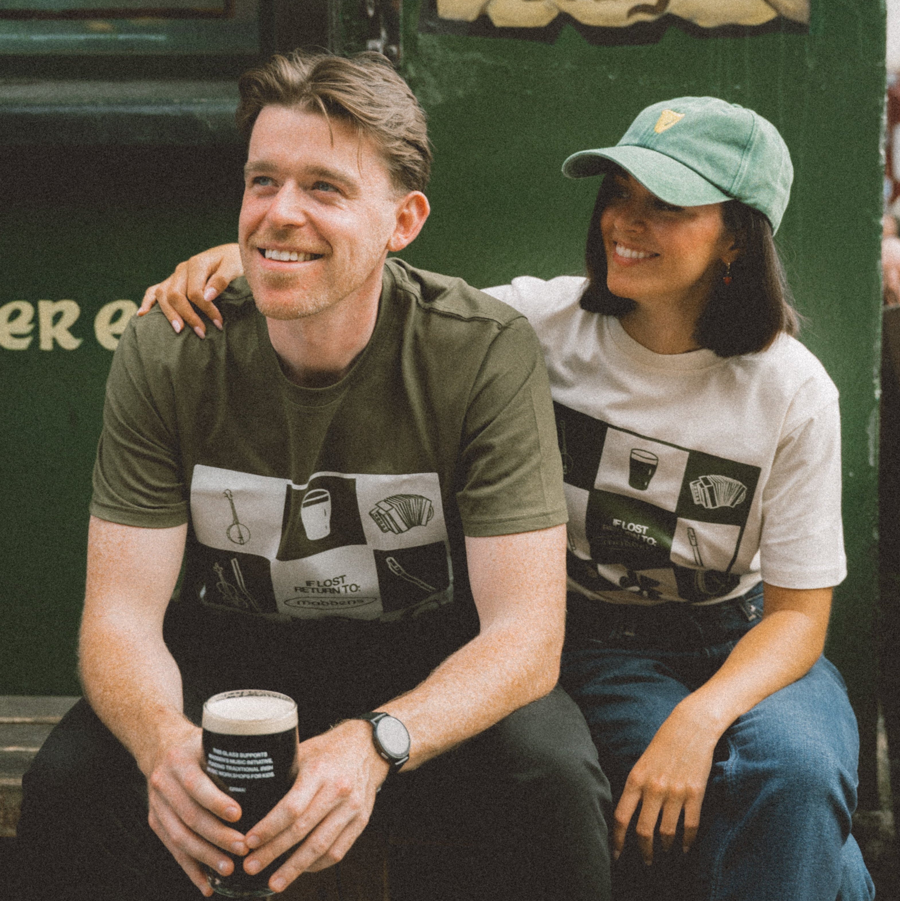 Two people sitting together outside maddens bar belfast wearing bronaghraff designs